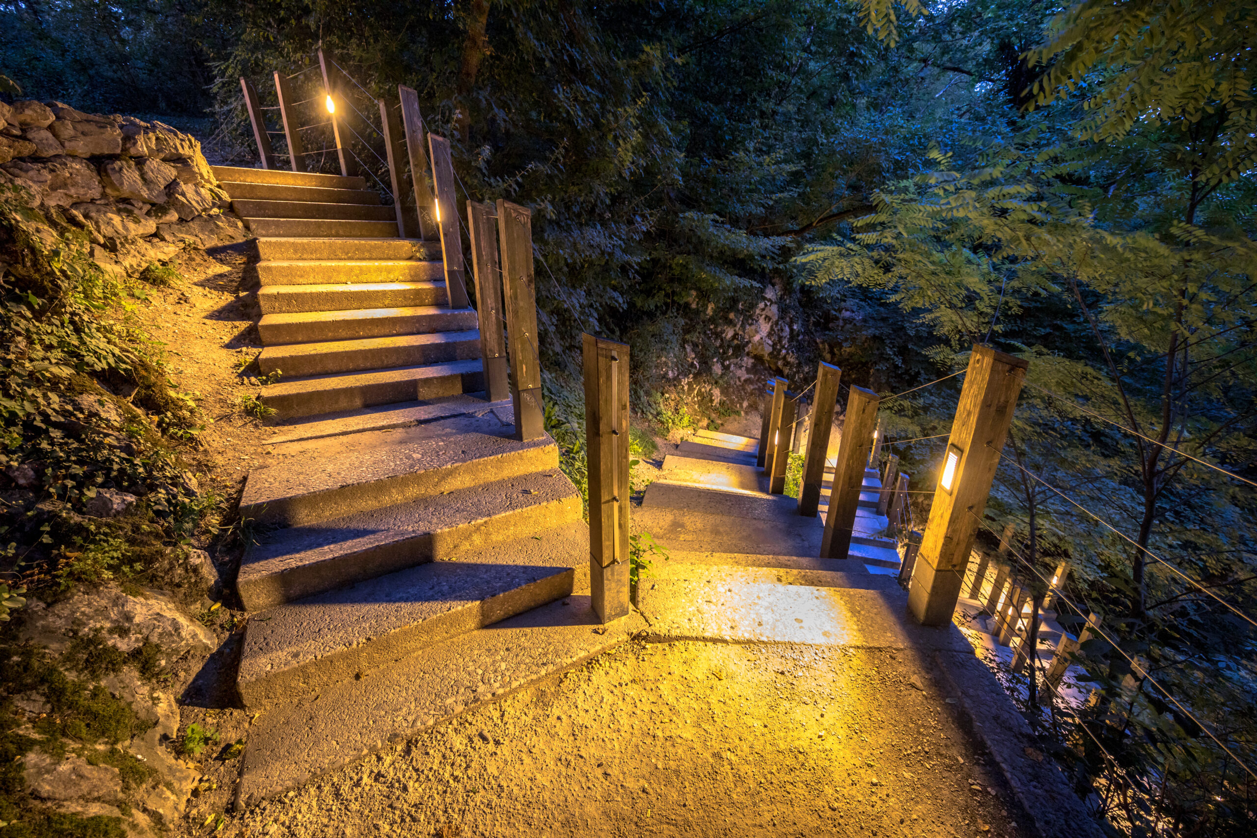 Illuminated outdoor Stairway down rocky mountain park at night